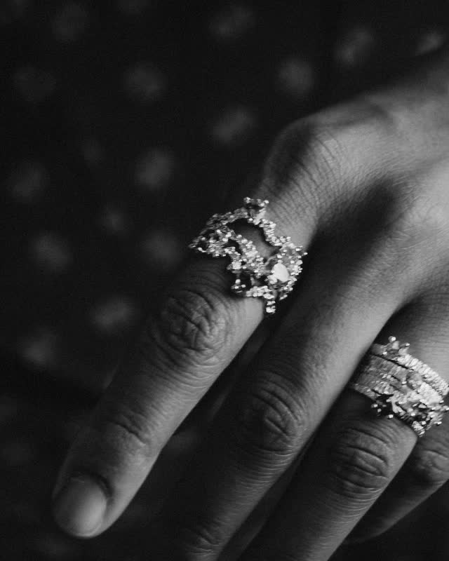 Close-up of a model's hand wearing two sculptural crystal rings