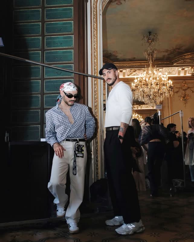 Two guests in shirtsleeves and sunglasses in a gilded salon