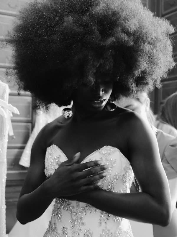 Model in a strapless embellished gown, hands crossed at the chest