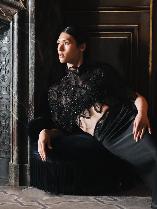 Model seated in black lace and feathers